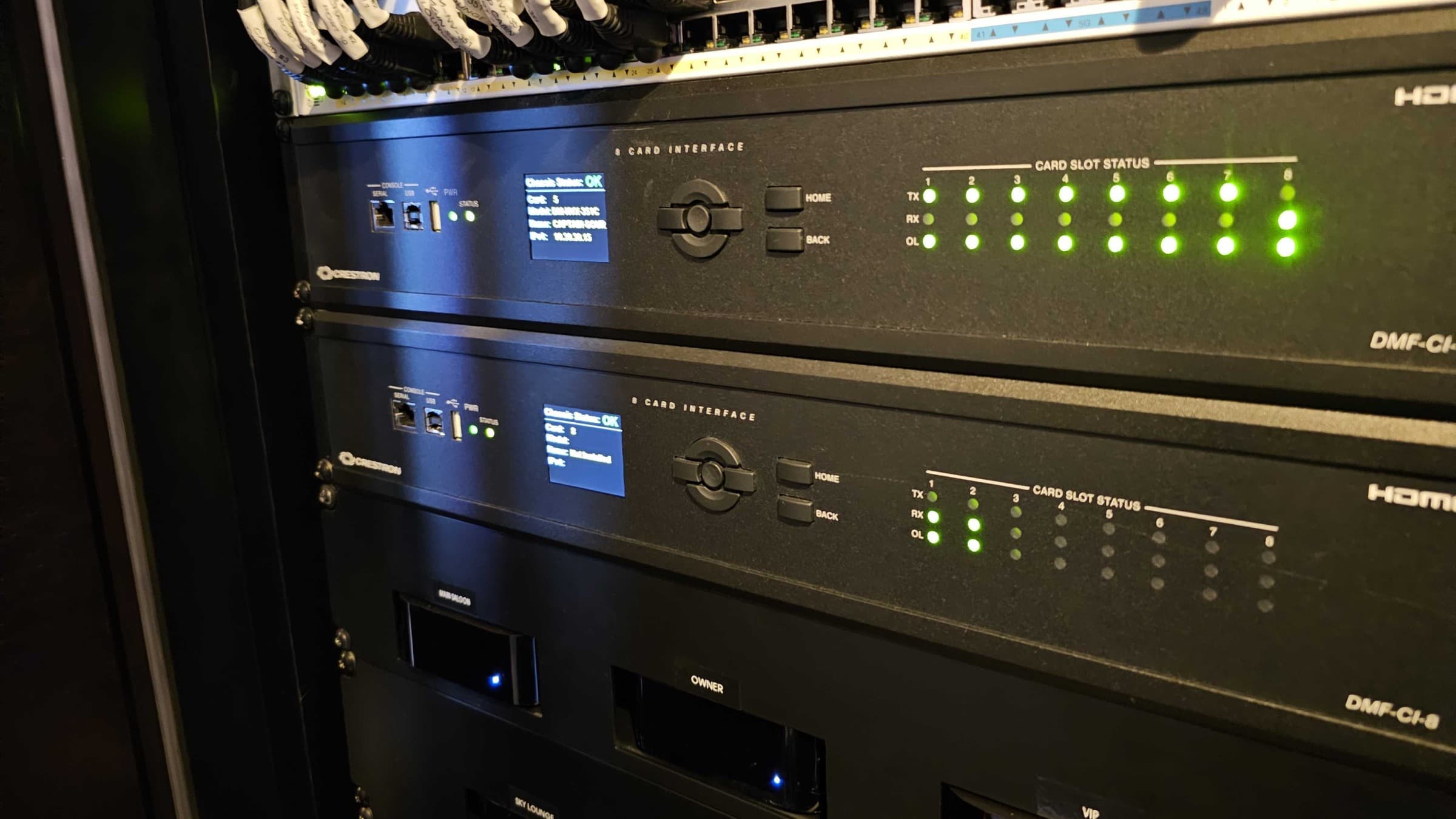 Two Crestron DMF-CI-8 card chassis populated with DM NVX cards, mounted below a 48-port managed switch in a superyacht AV rack