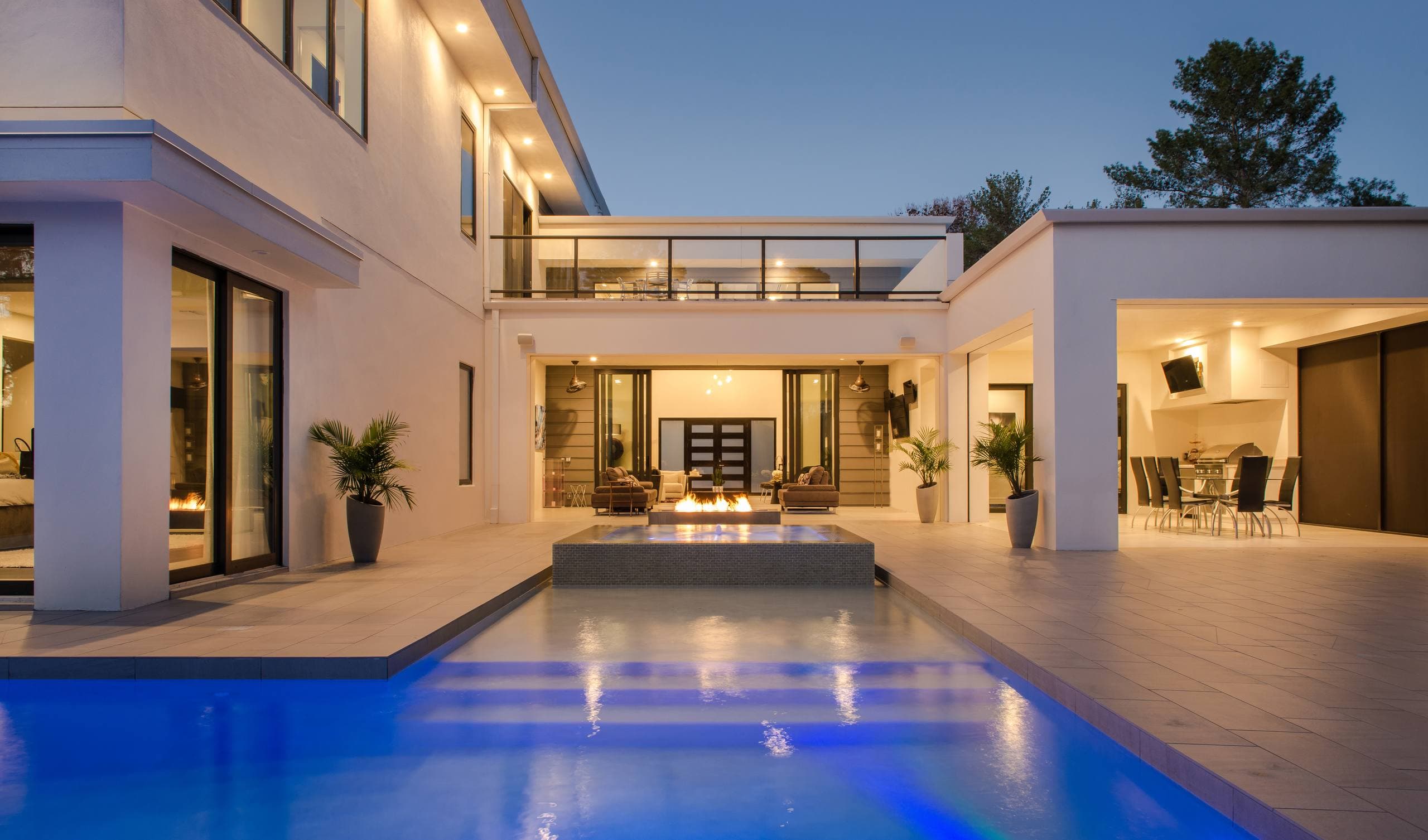 Luxury villa pool terrace at dusk with architectural and landscape lighting controlled by a home automation system